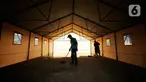 Pekerja membersihkan tenda darurat untuk ruang isolasi di Rumah Lawan COVID (RLC) Serpong, Tangerang Selatan, Kamis (11/2/2021). Pemkot Tangsel membangun tenda darurat berkonsep Tenda Glamour Camping (glamping) untuk menampung pasien Covid-19 di pusat karantina itu. (Liputan6.com/Angga Yuniar)