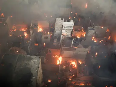 Suasana kebakaran yang melahap daerah kumuh di Manila, Filipina (23/5). Menurut laporan media setempat, kebakaran tersebut menghancurkan 200 rumah yang mempengaruhi 300 keluarga. (AFP Photo/Noel Celis)