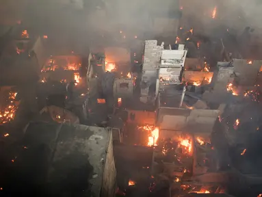 Suasana kebakaran yang melahap daerah kumuh di Manila, Filipina (23/5). Menurut laporan media setempat, kebakaran tersebut menghancurkan 200 rumah yang mempengaruhi 300 keluarga. (AFP Photo/Noel Celis)