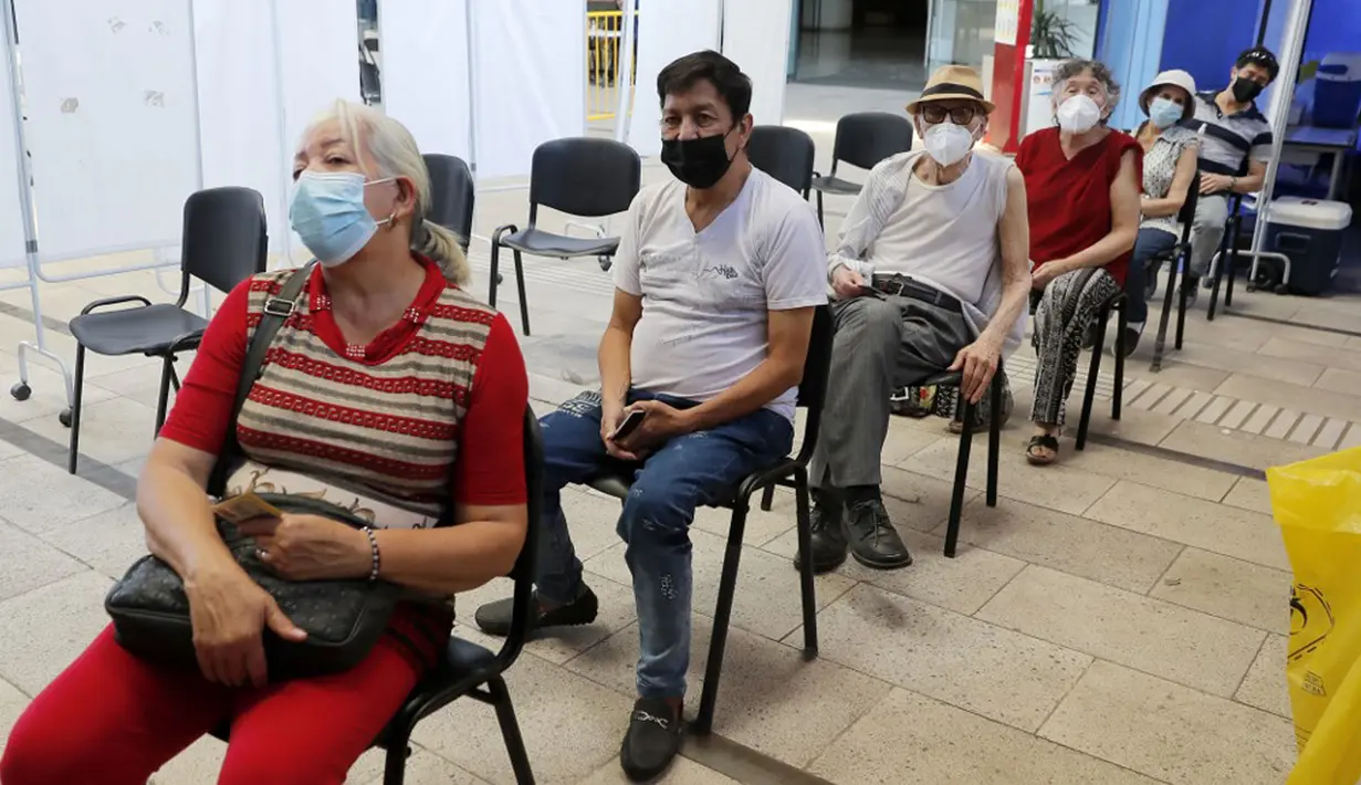 Sepasang lansia (ketiga dan keempat kanan) menunggu untuk menerima suntikan BioNtech Pfizer COVID-19 sebagai booster di Santiago, Chile, 7 Februari 2022. Di tengah gelombang COVID-19, Chile memulai vaksinasi dosis keempat untuk warga di atas usia 55 tahun. (JAVIER TORRES/AFP)