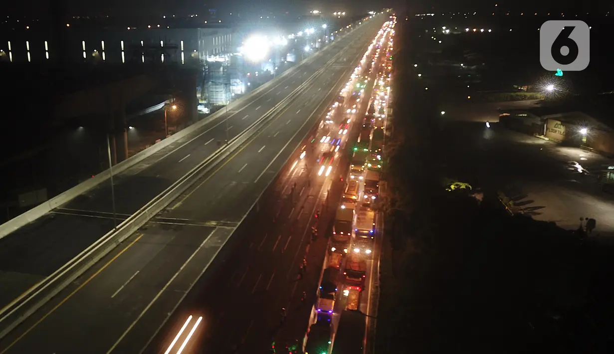 Polisi menghalau kendaraan berpenumpang di tol Jakarta-Cikampek untuk keluar ke Gerbang tol Cikarang Barat, Kab. Bekasi, Jumat (24/4/2020). Akses transportasi mobil pribadi dan bus angkutan penumpang dari tol Jakarta Cikampek menuju Karawang ditutup mulai Jumat (24/4). (Liputan6.com/Herman Zakharia)