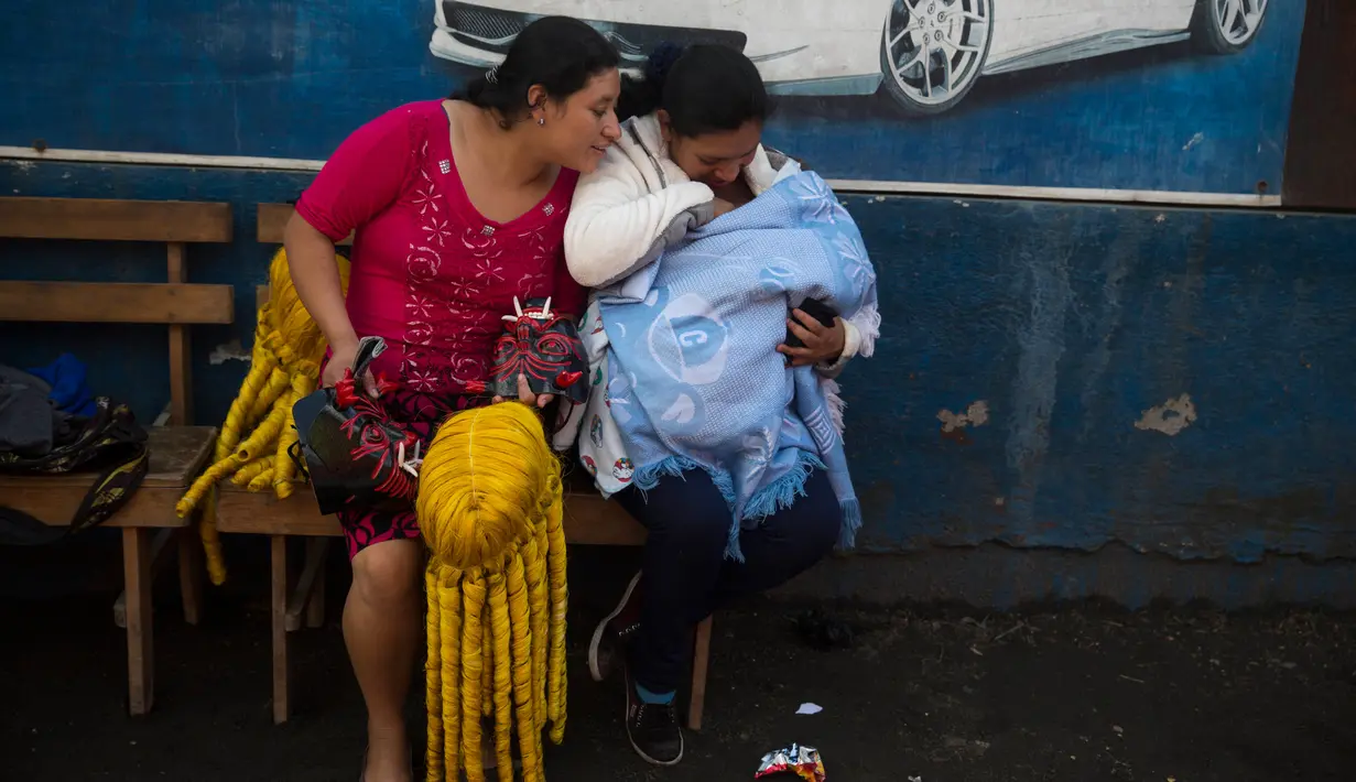Seorang wanita memegang wig dan kostum bersiap mengikuti parade perayaan Virgin of the Immaculate Conception di Ciudad Vieja, Guatemala (7/12). (AP Photo/Luis Soto)