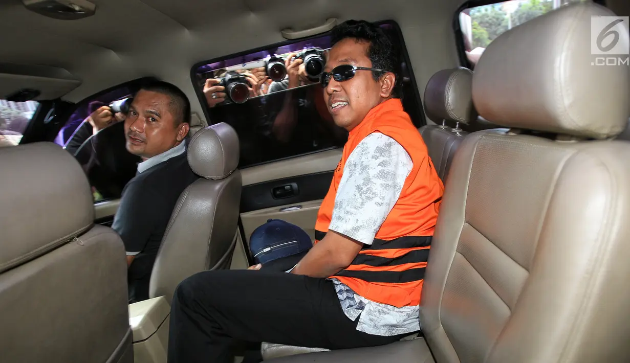 Ketua Umum PPP, Romahurmuziy dengan mengenakan rompi oranye memasuki mobil tahanan usai menjalani pemeriksaan di Gedung KPK, Jakarta, Sabtu (16/3). Romahurmuziy yang terjerat OTT di Surabaya pagi itu resmi menjadi tahanan KPK. (Liputan6.com/Faizal Fanani)