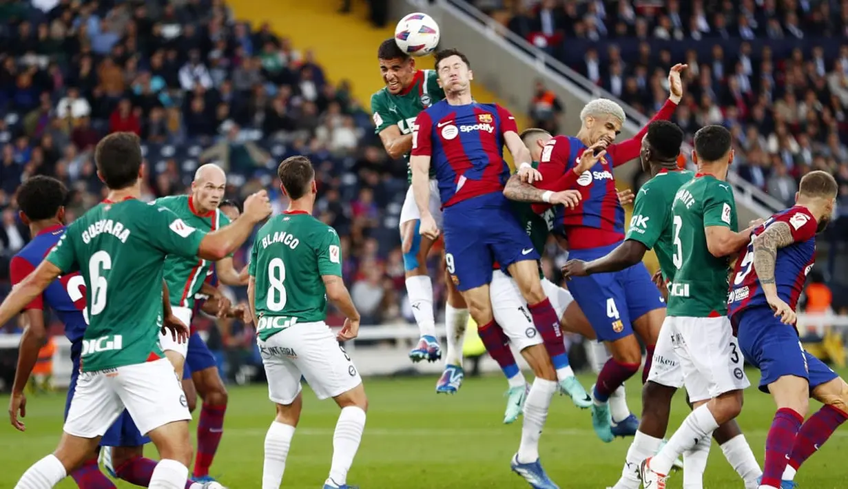Pemain Barcelona, Robert Lewandowski, duel udara dengan pemain Alaves, Abdel Abqar, pada laga pekan ke-13 La Liga 2023/2024 di Estadi Olímpic Lluís Companys, Minggu (12/11/2023). Dua gol yang disumbangkan Lewandowski menjadi momen kebangkitan sang pemain setelah mandul dalam enam pertandingan. (AP Photo/Joan Monfort)