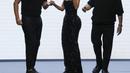 Kim Kardashian bersama Domenico Dolcedan Stefano Gabbana di akhir peragaan busana wanita Dolce & Gabbana Spring Summer 2023 di Milan, Italia, 24 September 2022. Anting yang dikenakan pun punya simbol salib, serasi dengan kalungnya. (AP Photo/Antonio Calanni)