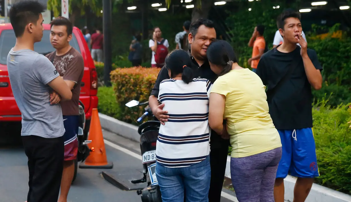 Dua wanita bereaksi setelah saudaranya selamat dari penembakan brutal di Resorts World Manila, Jumat (2/6). Serangan pria bersenjata dilaporkan telah melukai puluhan tamu hotel dan kasino yang berlarian setelah penembakan muncul (AP Photo/Bullit Marquez)