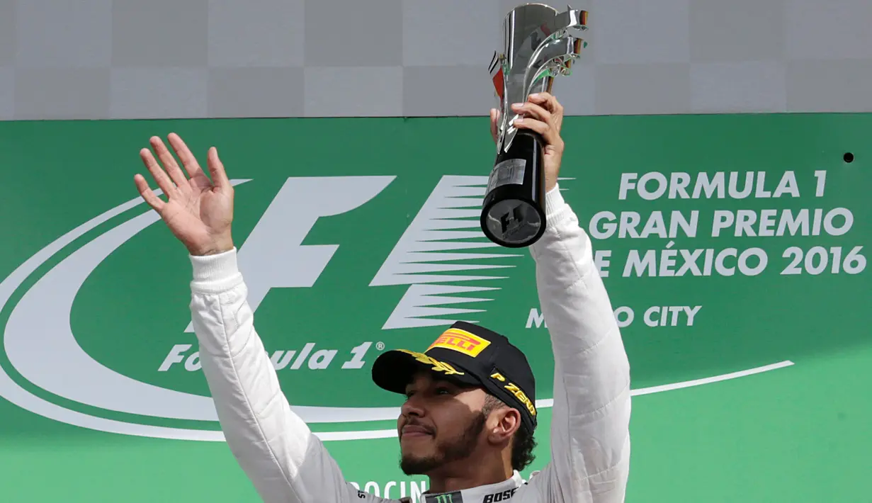 Pembalap tim Mercedes, Lewis Hamilton mengangkat trofi , setelah menjuarai balapan F1, di Grand Prix Meksiko yang berlangsung di Sirkuit Autodromo Hermanos Rodriguez, Mexico City, Meksiko (30/10). (Reuters/Henry Romero)
