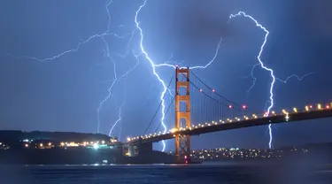 Kilatan petir terlihat di atas jembatan Golden Gate di San Francisco, California, AS (11/9). Petir merupakan Gejala alam yang biasanya muncul pada musim hujan di saat langit memunculkan kilatan cahaya sesaat yang menyilaukan. (AFP Photo/Josh Edelson)