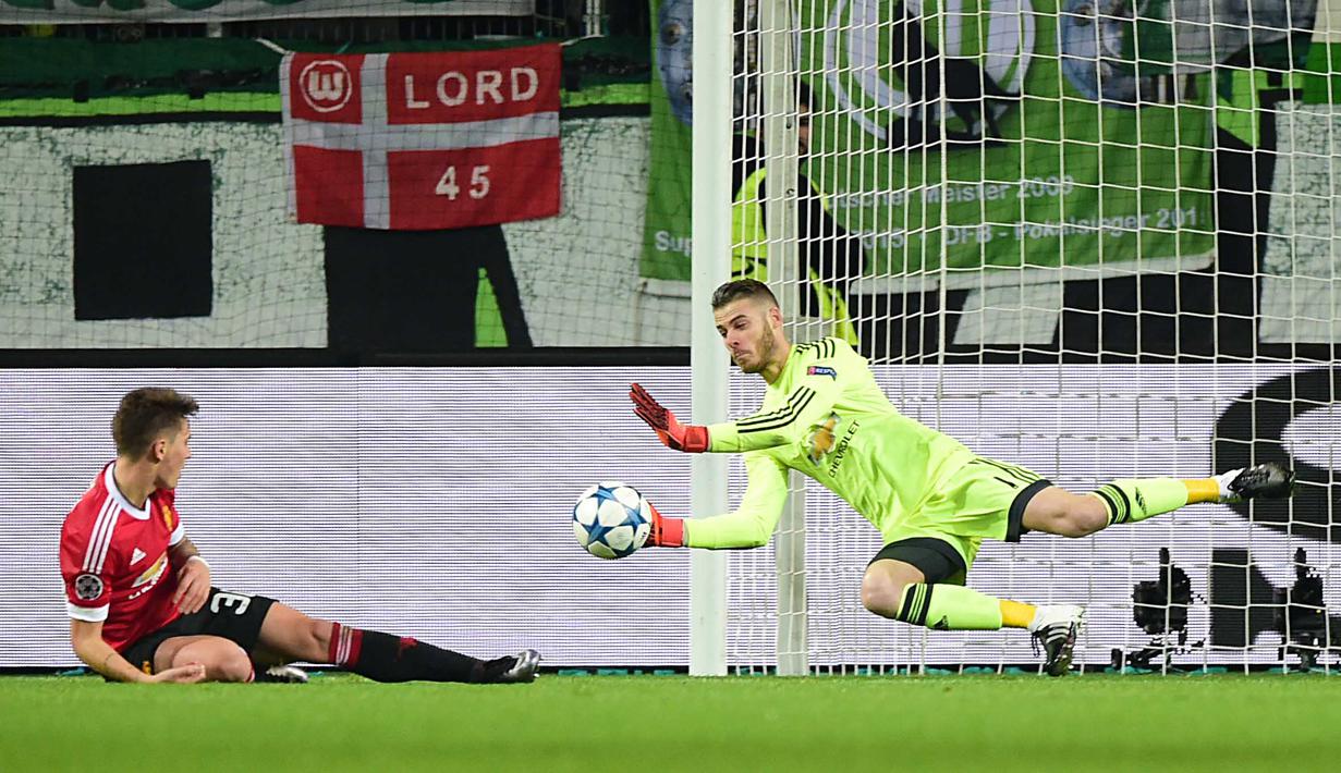 Kiper Manchester United, David de Gea (kanan) menghalau bola pada lanjutan liga Champions  di Stadion VfL Wolfsburg Arena; Rabu (9/12/2015) dini hari WIB. (AFP Photo/ Macdougall)