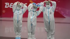Pekerja Olimpiade dengan pakaian pelindung berpose di bandara Beijing Capital International setelah Olimpiade Musim Dingin 2022, di Beijing, China, Senin (21/2/2022). (APhoto/Frank Augstein