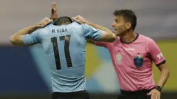 Bek timnas Uruguay, Matias Vina menutupi kepalanya setelah gagal melakukan tendangan penalti dalam laga perempat final Copa America 2021 di Stadion Nacional de Brasilia, Brasil, Minggu (4/7/2021) pagi WIB. Kolombia mengalahkan Uruguay lewat adu penalti dengan skor 4-2. (AP Photo/Silvia Izquierdo)