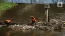 Petugas PPSU membersihkan sampah yang tersangkut di tengah derasnya aliran Kali Ciliwung, Jakarta, Rabu (19/5/2021). Pembersihan tersebut dimaksudkan agar tidak ada penumpukan sampah dan sedimentasi saluran di sepanjang Kali Ciliwung. (Liputan6.com/Faizal Fanani)