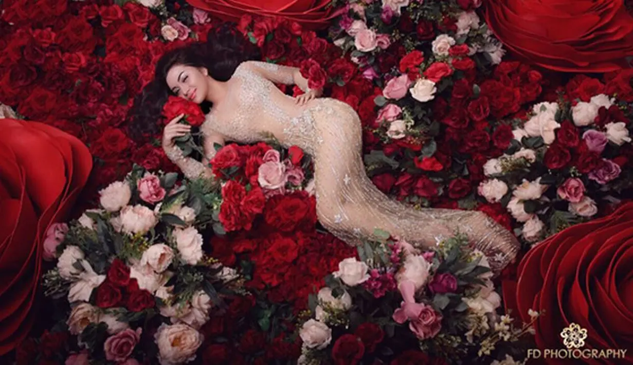 Dengan gaun transparan, Ariel Tatum tiduran di atas tumpukan bunga mawar. Lekuk tubuh yang terlihat jelas itu tampil mengoda. Meski terlihat, ia mengenakan kaos yang menyerupai warna kulitnya. (Instagram/arieltatum)