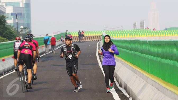 Warga bersepeda dan berlari di sepanjang jalan layang (elevated) Transjakarta rute Cileduk-Tendean di Jakarta, Minggu (26/2). (Liputan6.com/Immanuel Antonius)