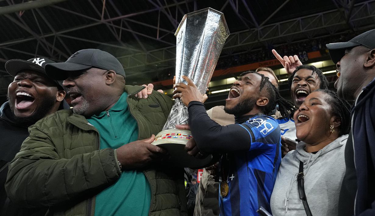 Pemain Atalanta, Ademola Lookman bersama keluarganya merayakan gelar juara Liga Europa 2023/2024 setelah berhasil menang pada laga final melawan Bayer Leverkusen di Dublin Arena, Irlandia, Kamis (23/05/2024) dini hari WIB. (AP Photo/Kirsty Wigglesworth)