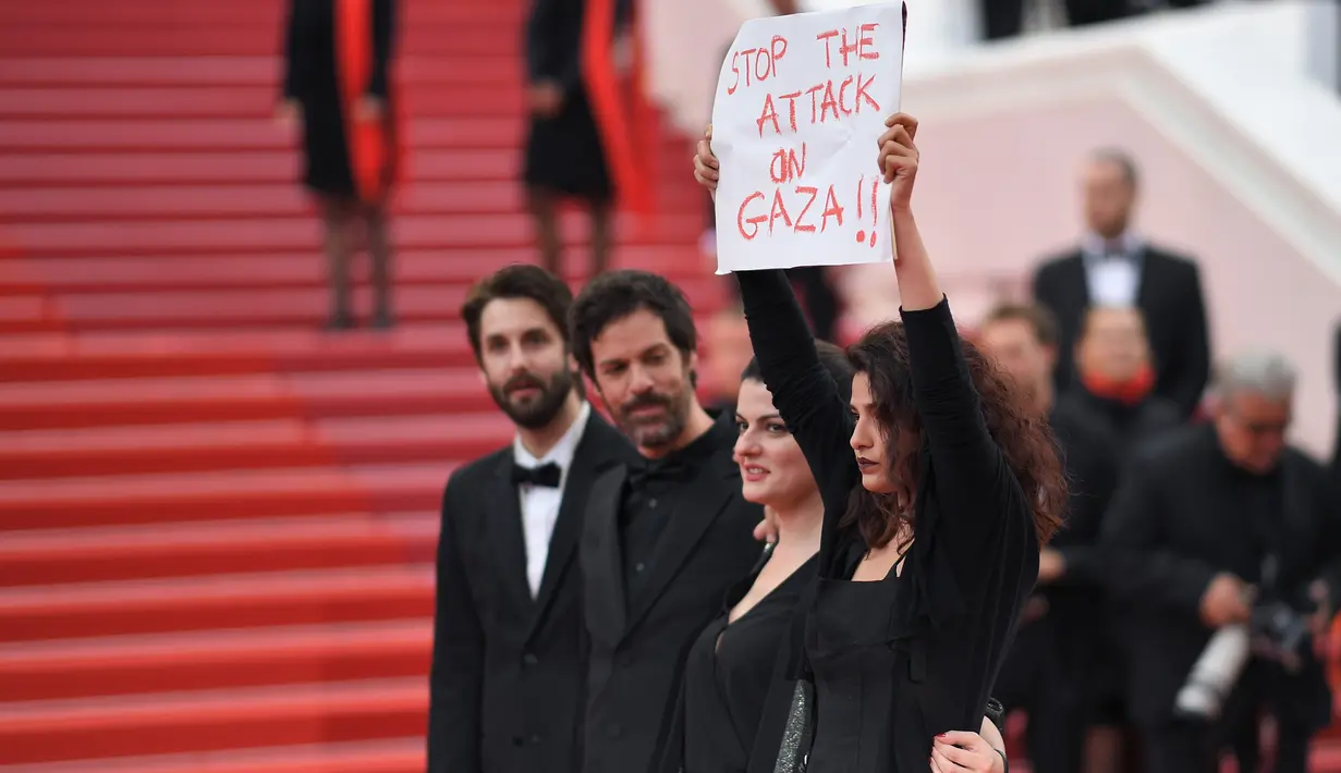 Aktris Manal Issa menujukkan poster bertuliskan "Hentikan Serangan di Gaza" saat menghadiri pemutaran film "Solo: A Star Wars Story" dalam Festival Film Cannes ke-71 di Cannes, Prancis (15/5). (AFP/Loic Venance)