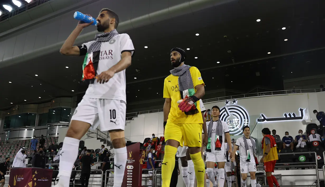 Para pemain Al Sadd memasuki lapangan sambil mengenakan keffiyeh yang dikalungkan di leher. (Qatar Football Associations)
