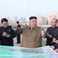 Pemimpin Korea Utara Kim Jong-un memberikan arahan kepada stafnya saat mengunjungi lokasi konstruksi pembangunan gedung apartemen di tepi Sungai Pothong, Korea Utara, Kamis (1//4/2021)..( STR/KCNA VIA KNS/AFP)