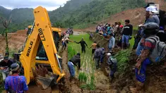 Warga memandu alat berat melalui jalan kecil menuju lokasi longsor di Dusun Cimapag, Sirnaresmi, Cisolok, Sukabumi, Jawa Barat, Selasa (1/1). Alat berat dikerahkan untuk mencari korban yang hilang. (Merdeka.com/Arie Basuki)