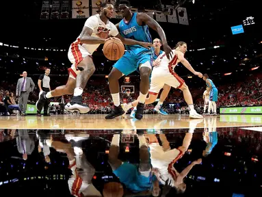 Pebasket Miami Heat, James Johnson (kiri) mencoba melewati adangan pebasket Hornets, Johnny O'Bryant III #8  pada laga NBA pre-season di American Airlines Arena, Miami, (9/10/2017). Miami Heat menang 109-106. (Mike Ehrmann/Getty Images/AFP)