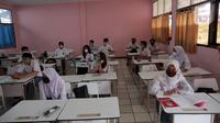 Siswa mengikuti uji coba pembelajaran tatap muka (PTM) terbatas di SMAN 1 Kota Tangerang, Banten, Senin (6/9/2021). Dinas Pendidikan Provinsi Banten uji coba PTM di SMA di Kota Tangerang secara terbatas dengan sistem bergiliran serta menerapkan protokol kesehatan ketat. (Liputan6.com/Angga Yuniar)