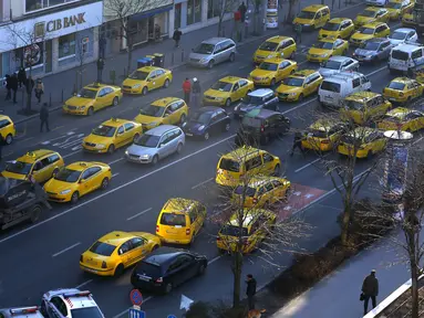 Taksi memblokir jalan utama di pusat kota Budapest, Hongaria, (18/1). Pengemudi taksi konvensional memprotes taksi online Uber yang beroperasi d Hongaria. (REUTERS / Laszlo Balogh)