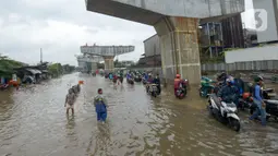 Pengendara mendorong motornya melintasi banjir di Jalan Raya Bekasi, Jakarta Timur, Selasa (25/2/2020). Banjir akibat hujan yang melanda Bekasi sejak Selasa (25/2) dini hari memutus beberapa titik jalan raya di wilayah setempat. (merdeka.com/Imam Buhori)