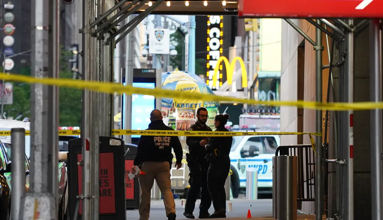 Petugas polisi melakukan pemeriksaan di lokasi penembakan di Times Square di New York, AS (8/5/2021). Penembakan brutal terjadi di kawasan Times Square, dekat West 44th St. dan 7th Ave di New York yang mengakibatkan 3 orang terluka termasuk bocah perempuan berusia 4 tahun. (AFP/Kena Betancur)