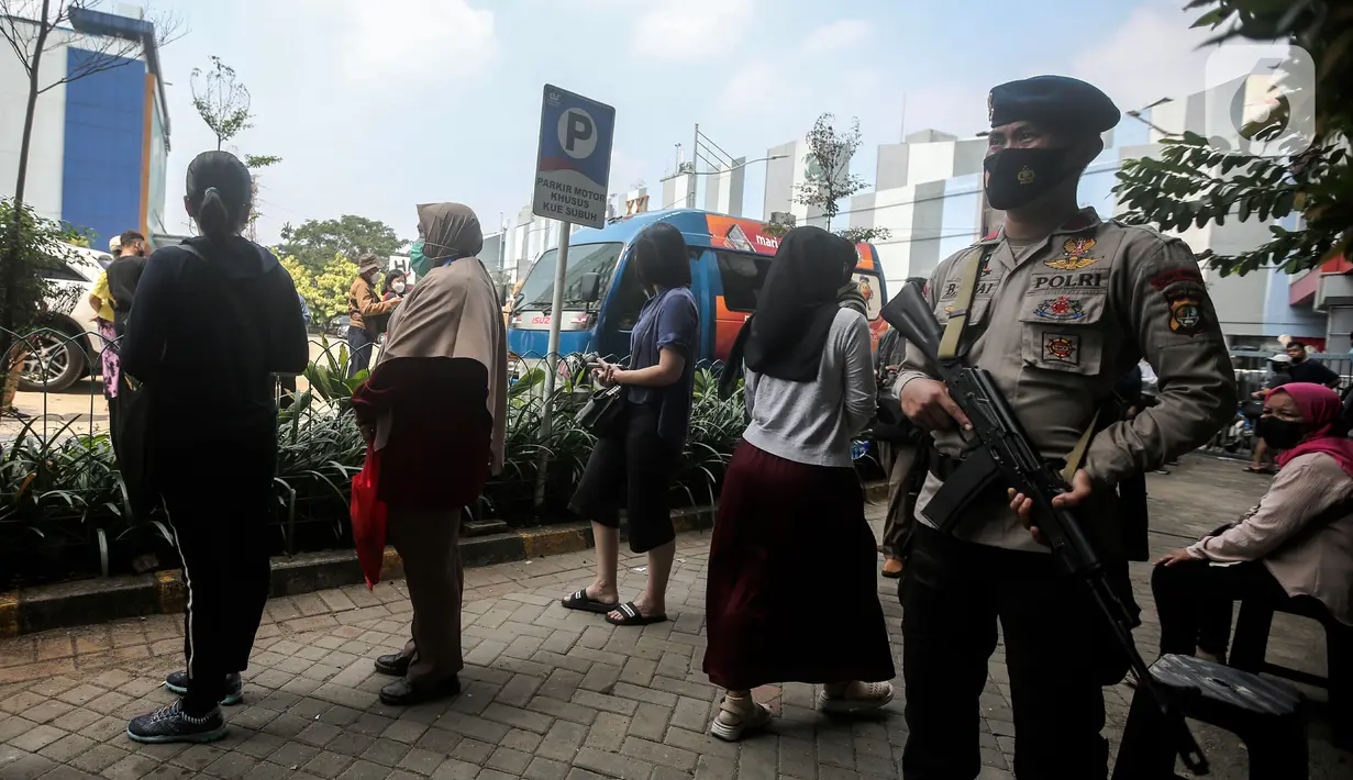Polisi berjaga saat warga menukarkan uang rupiah kertas baru emisi 2022 di Pasar Senen, Jakarta, Selasa (23/8/2022). Bank Indonesia (BI) memastikan uang tersebut sudah bisa tersedia di ATM perbankan konvensional mulai 19 Agustus 2022. (Liputan6.com/Faizal Fanani)