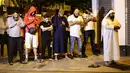 Sejumlah pria muslim melaksanakan salat di lokasi sebuah van yang menabrak pejalan kaki di Finsbury Park Road, London utara, Senin (19/6). Polisi menyebut van menabrak kerumunan orang yang baru selesai salat di masjid Finsbury Park (Yui Mok/PA via AP)