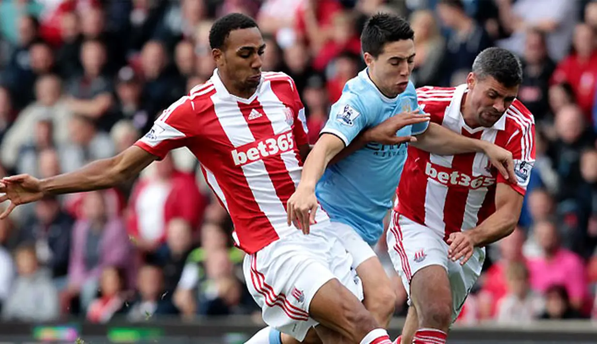 Dua pemain Stoke City Steven N'Zonzi (kiri) dan Jonathan Walters (kanan) menghadang gelandang Manchester City Samir Nasri (tengah) pada pertandingan sepak bola Liga Premier Inggris antara Stoke kota vs Manchester City di stadion Britannia (14/09/13). (AFP