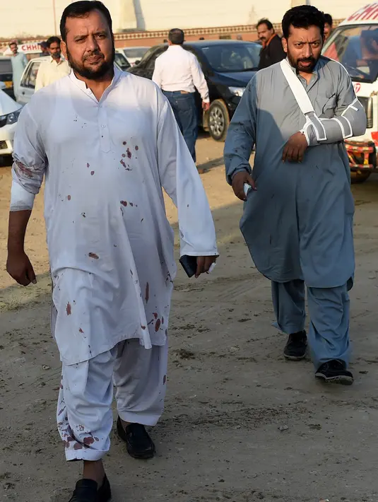 Tamu hotel yang mengalami cedera berjalan di luar sebuah hotel mewah menyusul kebakaran yang terjadi di Karachi, Pakistan, Senin (5/12). Kebanyakan gedung-gedung di Pakistan memiliki standar keselamatan dan kesehatan yang buruk. (RIZWAN Tabassum/AFP)