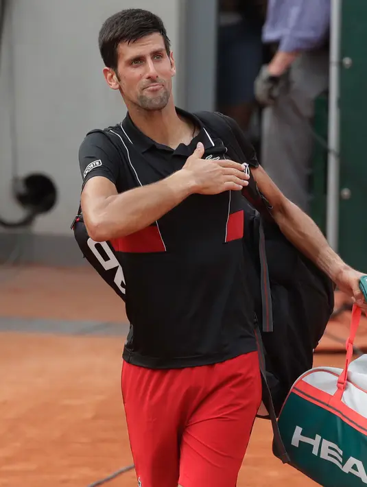 Petenis Serbia, Novak Djokovic meninggalkan lapangan seusai kalah dari petenis Italia Marco Cecchinato pada perempatfinal Prancis Terbuka 2018, Selasa (5/6). Djokovic dikalahkan petenis non-unggulan dalam duel empat set. (AP/Alessandra Tarantino)