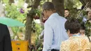 Barack Obama menunggu kelapa yang sedang di buka di sepanjang Sungai Mekong di Luang Prabang, Laos (7/9). Obama menjadi presiden AS pertama yang mengunjungi Laos dan mendarat di Vientiane akhir pada 5 September. (AFP PHOTO/SAUL Loeb)