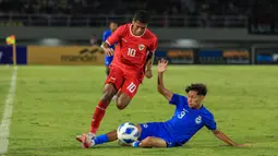 Striker Timnas Indonesia U-16, Fadly Alberto berusaha melewati adangan bek Singapura, Muhammad Luth Harith pada laga matchday pertama Grup A Piala AFF U-16 2024 di Stadion Manahan, Solo, Jumat (21/6/2024). (Bola.com/Radifa Arsa)