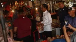 Presiden Joko Widodo atau Jokowi saat blusukan di Pasar Minggu, Jakarta, Jumat (22/2). Jokowi menyusuri jalan yang masih becek lantaran habis hujan dan belum dibersihkan petugas. (Liputan6.com/Angga Yuniar)