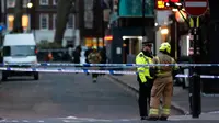 Polisi berbincang dengan petugas pemadam kebakaran saat penemuan bom Perang Dunia II di kawasan Soho, London, Inggris, Senin (3/2/2020). Polisi mengevakuasi warga yang berada di kafe, restoran, pub, dan kantor radius beberapa blok dari lokasi penemuan bom. (AP Photo/Frank Augstein)