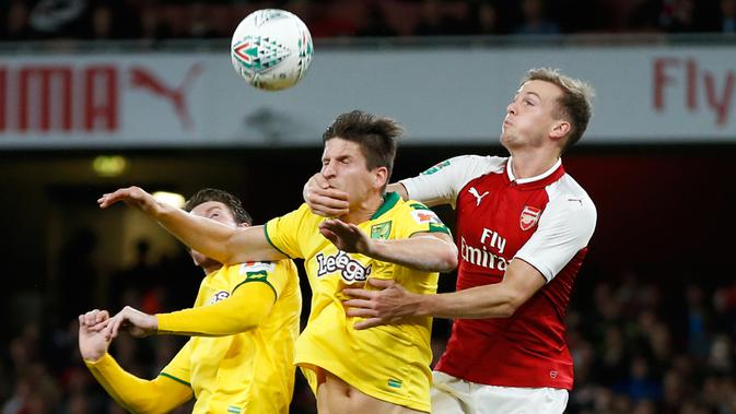 Pemain Arsenal, Rob Holding berusaha menyundul bola dari pemain Norwich City, Timm Klose pada lanjutan Piala Liga Inggris di Emirates Stadium, Rabu (25/10). Edward Nketiah memborong gol Arsenal saat mengalahkan Norwich City 2-1. (AP/Alastair Grant)