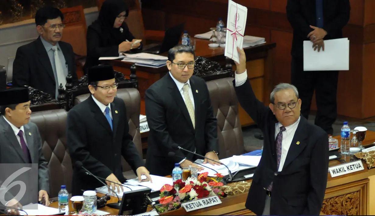 Ketua Komisi II DPR Rambe Kamarulzaman menyerahkan hasil pandangannya terkait pengesahan Revisi UU tentang Pilkada keada Ketua Sidang Taufik Kurniawan disaksikan Ketua DPR Ade Komarudin (kedua kanan), Jakarta, Kamis (2/6/2016). (Liputan6.com/Johan Tallo)