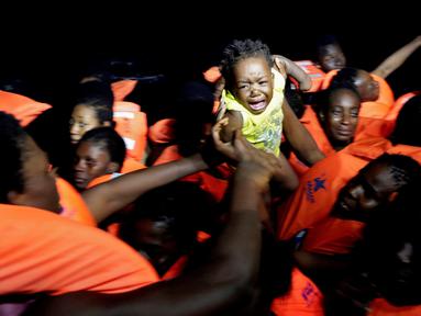 Seorang anak imigran menangis saat operasi penyelamatan di laut Mediterrania, (20/10). Penjaga pantai Italia mengatakan ribuan imigran berhasil diselamatkan di lepas pantai Libya. (Yara Nardi/Italian Red Cross press office/Handout via REUTERS)
