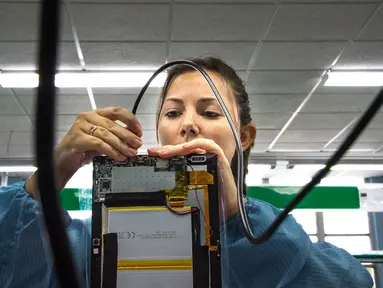 Teknisi wanita menyelesaikan proses perakitan tablet PC berteknologi Haier China di sebuah pabrik Industri Informatika, Komunikasi dan Elektronika Kuba (Gedeme), Havana, Kuba (15/5). (AFP Photo/Adalberto Roque)