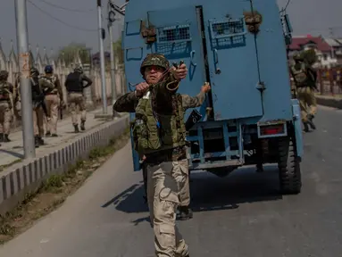 Seorang tentara paramiliter India menggunakan ketapel selama bentrok dengan pengunjuk rasa selama protes terhadap pembunuhan pemberontak di Srinagar, Kashmir yang dikuasai India, (1/4). (AP Photo / Dar Yasin)