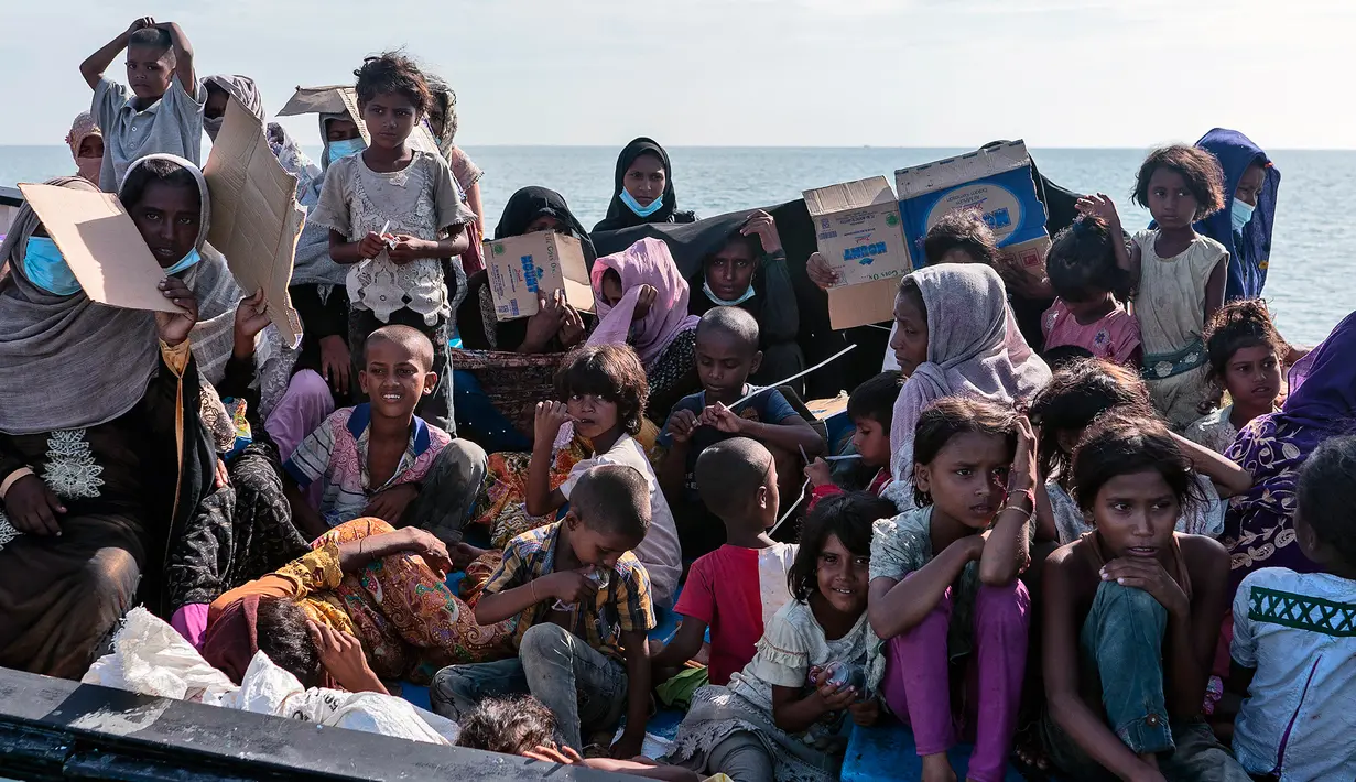 Pengungsi etnis Rohingya duduk di atas kapal saat mereka tiba di pesisir pantai Lancok, di Kabupaten Aceh Utara, Kamis (25/6/2020). Nelayan Indonesia menemukan hampir 100 orang etnis Rohingya, termasuk 30 orang anak-anak terdampar di tengah laut dengan kondisi kapal rusak. (AP Photo/Zik Maulana)