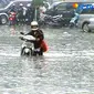 Seorang pengendara sepeda motor menerobos banjir di Jalan Sabang, Jakarta Pusat. Banjir terjadi akibat hujan deras pada Senin (8/6) siang.