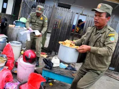 Dua anggota Satpol PP Kota Pontianak mengangkut barang dagangan milik seorang Pedagang Kaki Lima (PKL), saat melakukan penertiban di Jalan Alianyang, Pontianak, Kalbar, Selasa (10/4). Secara berkesinambungan Satpol PP melakukan penertiban PKL di sejumlah titik kota, guna menciptakan Pontianak yang bersih dan rapi. (Antara)