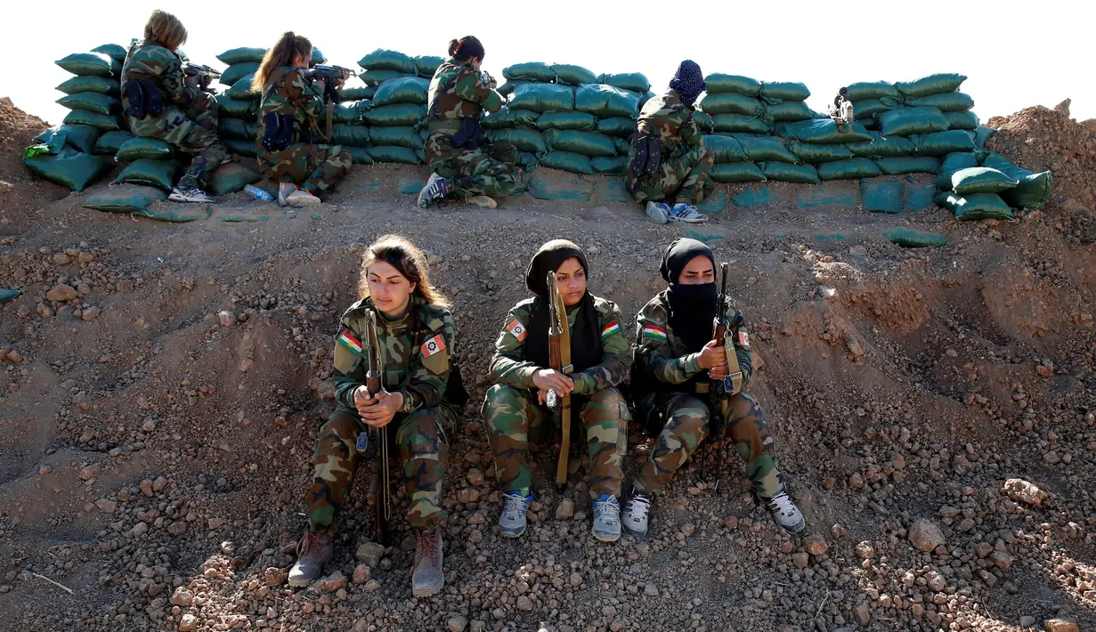 Sejumlah pejuang wanita Iran-Kurdi siap siaga saat bertempur melawan kelompok ISIS di Bashiqa, dekat Mosul, Irak, Kamis (3/11). Sebelumnya, mereka telah dilatih untuk piawai menggunakan senapan kelas berat, sedang dan ringan. (Reuters/Ahmed Jadallah)
