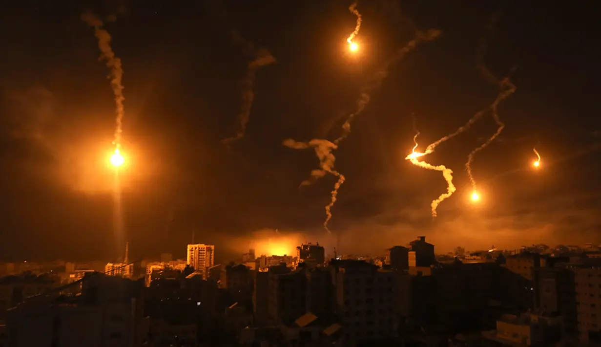 Suar pasukan Israel menerangi langit malam di Kota Gaza, Senin (6/11/2023). Pasukan Israel terus melakukan serangan terhadap Gaza untuk mengincar militan Hamas. (AP Photo/Abed Khaled)