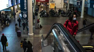 Orang-orang tiba di stasiun kereta Union Station di Washington, DC, Kamis (23/12/2021). Jutaan orang Amerika bepergian pada 23 Desember 2021, selama salah satu hari perjalanan tersibuk di musim liburan, ketika infeksi Covid dengan Omicron melampaui puncak gelombang varian Delta. (Pedro Ugarte/AFP)