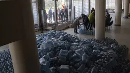 Penduduk setempat menerima air minum di pusat distribusi di Toretsk, Ukraina timur, pada 25 April 2022. Penduduk Toretsk tidak memiliki akses air selama lebih dari dua bulan karena perang Rusia Ukraina. (AP Photo/Evgeniy Maloletka)