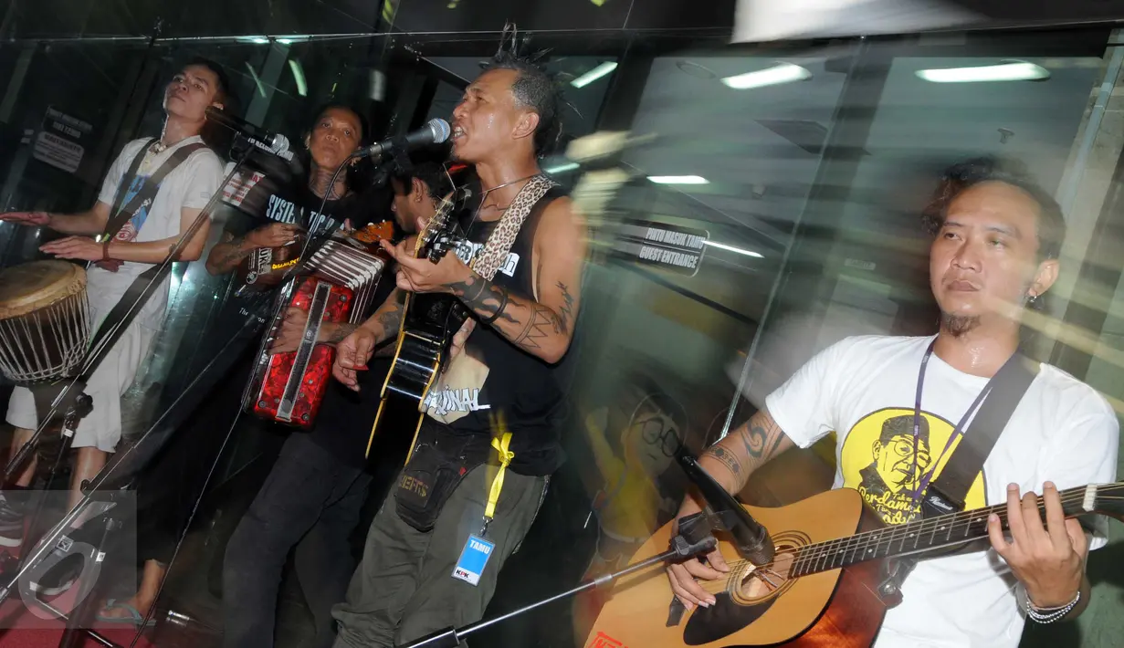 Band Punk Marjinal beraksi didepan Gedung KPK, Jakarta, Rabu (17/2). Vokalis Marjinal Mike menilai, revisi undang-undang tersebut lebih banyak membawa keburukan dan membuka jalan bagi para koruptor selamat dari jerat hukum. (Liputan6.com/Helmi Afandi)